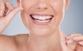 Staving off those cavities. Studio shot of an unrecognizable young woman using dental floss against a grey background. Royalty Free Stock Photo