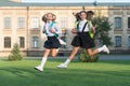 Stay active. Active girls run from school. Happy kids afterschool. Active childhood. School holidays. Summer vacation Royalty Free Stock Photo