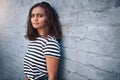 Stay authentically true to who you are. Portrait of a young woman standing against a grey wall. Royalty Free Stock Photo