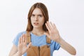 Stay away from me. Portrait of concerned displeased and serious young woman raising palms in protection gesture frowning Royalty Free Stock Photo