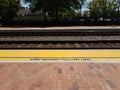 stay behind yellow line sign and train tracks