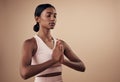 Stay centered and balanced. an attractive young woman standing alone in the studio and holding a meditative pose while