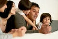 Stay connected. Happy latin family with little kids using digital tablet, lying on the bed together. Parents and Royalty Free Stock Photo