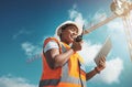 Stay in contact, stay on track. a young woman using a digital tablet and walkie talkie while working at a construction Royalty Free Stock Photo