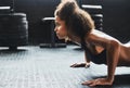 Stay determined and do whats best for you. a young woman doing pushups in a gym.
