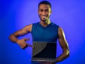 Man Showing Laptop Blank Screen Recommending Online Workout, Blue Background Royalty Free Stock Photo