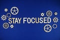 Stay Focused alphabet letters with gears element on navy blue background Royalty Free Stock Photo