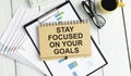 STAY FOCUSED ON THE END GOAL notepad writing