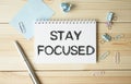 STAY FOCUSED text on notebook on wooden Royalty Free Stock Photo