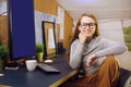 Stay home, a chic girl works in a homely atmosphere. Girl freelancer working at a computer with glasses