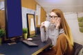 Stay home, a chic girl works in a homely atmosphere. Girl freelancer working at a computer with glasses, looking at a green screen