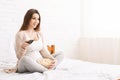 Pregnant woman watching tv at home with popcorn Royalty Free Stock Photo