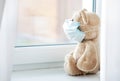 Stay home concept,quarantine,teddy bear in maskon windowsill,coronaviruis pandemic prevention Royalty Free Stock Photo