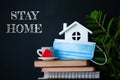 Stay home concept of selfisolation during the Covid-19 coronavirus pandemic. Cute home interior, house, books, flowers and the