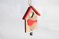 Stay home concept. Wooden Christmas toy house with red roof and bird on white background. Christmas decoration concept Royalty Free Stock Photo