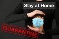 Stay at home during coronavirus quarantine. Woman holding house model with medical mask on dark background Royalty Free Stock Photo