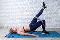 Woman doing exercise for glute hip bridge with a leg up abduction using rubber resistance band Royalty Free Stock Photo