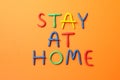 Stay at home made of plasticine on orange background