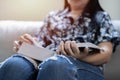 Stay home pastimes. Asian woman sitting in cozy sofa with open book indoors Royalty Free Stock Photo