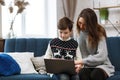 Stay home. Portrait of smiling mother and son using laptop for a online meeting, video call, video conference with Royalty Free Stock Photo