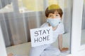 Stay at home quarantine coronavirus pandemic prevention. Sad child both in protective medical masks near windows and looks out Royalty Free Stock Photo