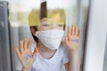 Stay at home quarantine coronavirus pandemic prevention. Sad child both in protective medical masks near windows and looks out Royalty Free Stock Photo