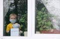 Stay at home quarantine for coronavirus pandemic prevention. Sad child and his teddy bear both in protective medical masks sits on Royalty Free Stock Photo