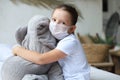 Stay at home quarantine coronavirus pandemic prevention. Sad child in protective medical mask and his elephant Royalty Free Stock Photo