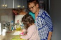 Child help at home.Cooking with kids,healthy food,family love.Toddler girl with grandmother in kitchen peeling carrots.