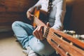Stay Home Stay Safe. Young woman sitting at home and playing guitar, hands close up. Teen girl learning to play song and