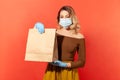 Stay home, shopping safe. Woman in protective mask and gloves holding paper bag, food purchase Royalty Free Stock Photo