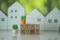 `STAY HOME STAY SAFE` text on wooden blocks and miniature cactus white wood home blur background. Royalty Free Stock Photo