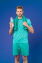 Stay hydrated. Man with towel on shoulders hold bottle. Athlete drink hydration mix with more electrolytes. Hydrates Royalty Free Stock Photo