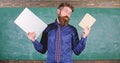 Stay modern with technology. Teacher bearded hipster holds book and laptop. Modern technologies benefit. Digital against