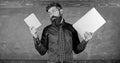 Stay modern with technology. Teacher bearded hipster holds book and laptop. Modern technologies benefit. Digital against