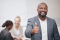 Stay optimistic and you will succeed. Portrait of a mature businessman showing thumbs up in an office with his Royalty Free Stock Photo