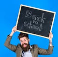 Stay positive. Teacher bearded man holds blackboard with inscription back to school blue background. Teacher with