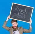 Stay positive. Teacher bearded man holds blackboard with inscription back to school blue background. Teacher with