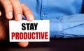 STAY RODUCTIVE is written on a white business card in a man`s hand. Advertising concept Royalty Free Stock Photo