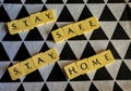 STAY SAFE STAY HOME - scrabble tiles against black and white textured background