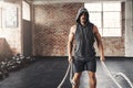 Stay strong, end stronger. a muscular young man working out with battle ropes in a gym. Royalty Free Stock Photo