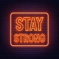 Stay strong neon inspirational quote on a brick wall.