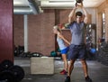 Stay strong, stay fit. two people working out with kettlebells in a gym. Royalty Free Stock Photo