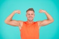 Stay strong in your life. Happy athlete show physical strength. Strong man flex arms blue background. Building strong