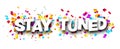 Stay tuned sign with colorful cut out ribbon confetti background Royalty Free Stock Photo