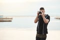 Stay where you are, this photo is amazing. Portrait of creative good-looking freelance photographer looking through