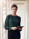 Staying ahead of the curve. Cropped portrait of an attractive young businesswoman using her tablet while standing in the