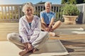 Staying fit and healthy through yoga. Portrait of a senior couple doing yoga together on their patio outside. Royalty Free Stock Photo