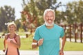 Staying healthy and fit. Happy mature man smiling at camera while running together with his wife in the early morning Royalty Free Stock Photo