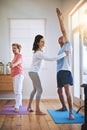 Staying healthy one stretch at a time. a teacher helping a senior man during a yoga class. Royalty Free Stock Photo